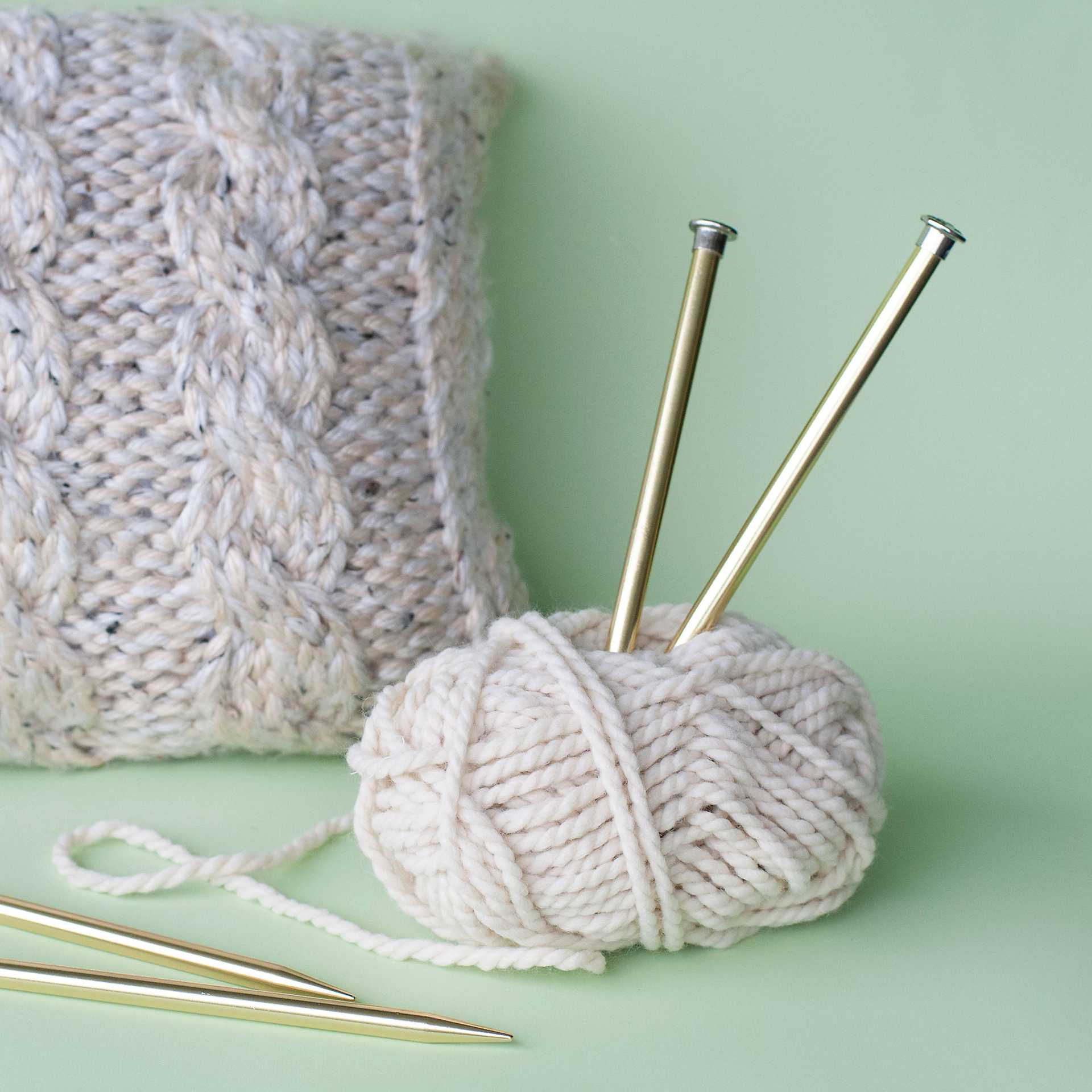 Boye Aluminum Knitting Needles - US 13, 10", in use with yarn (not included) and finished pillow example