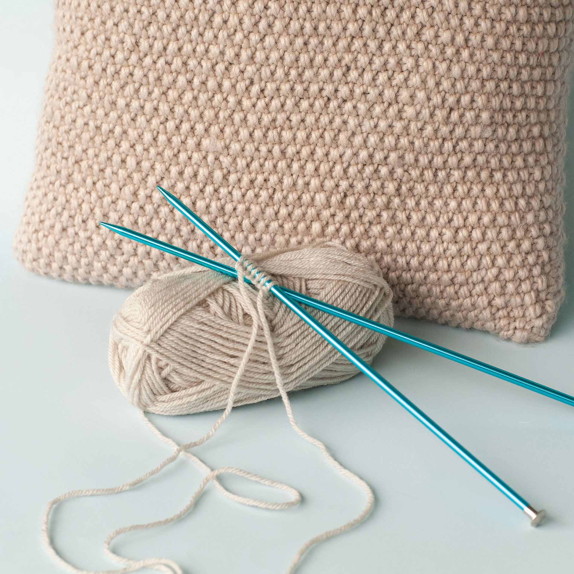 Boye Aluminum Knitting Needles - US 10 - on yarn (not included) next to finished pillow example 
