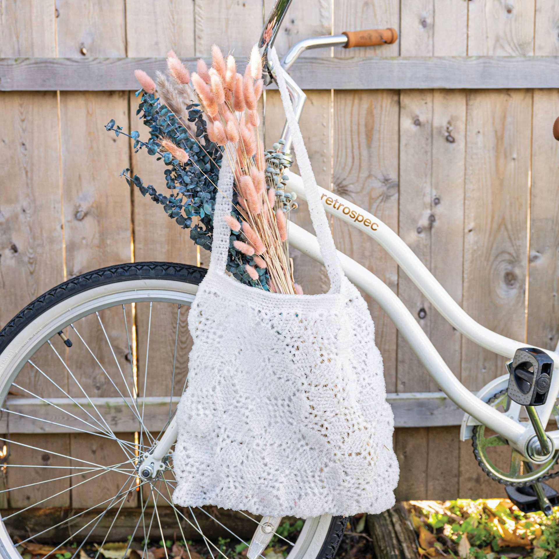 Lion Brand Stitch Soak Scrub Yarn - Coconut Milk finished tote bag hanging off bike handlebar