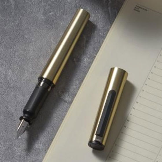 Sailor TUZU Adjust Fountain Pen - Gold, Fine, pen and cap resting on tabletop with stationary.