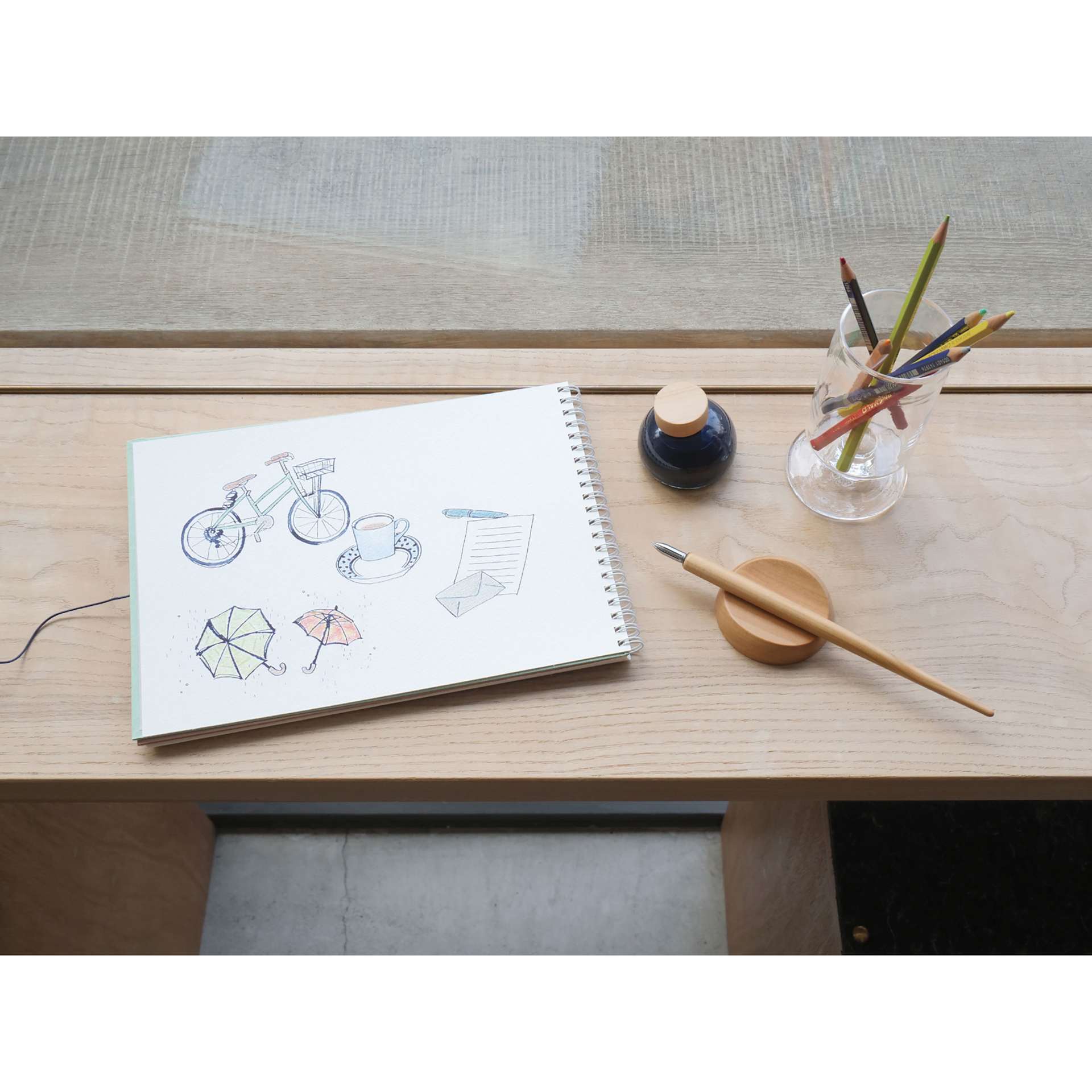 Kakimori Sakura Wood Pen Rest - Japanese Cherry, in use next to ink bottle