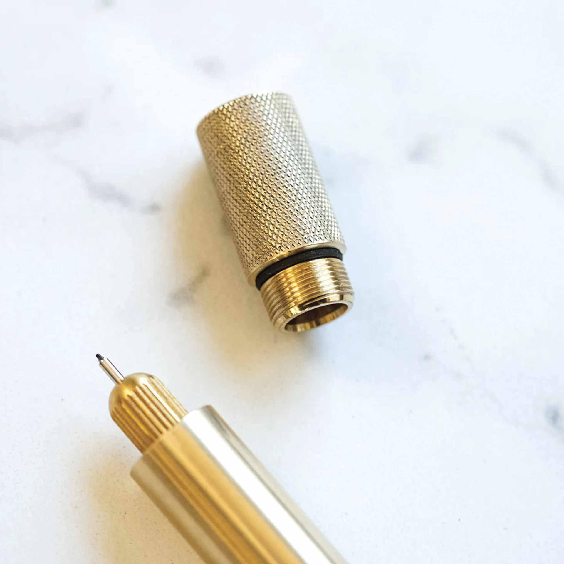 Tom's Studio Lumos Pro Refillable Single Tip Pen - Brass, close-up of the top of the pen