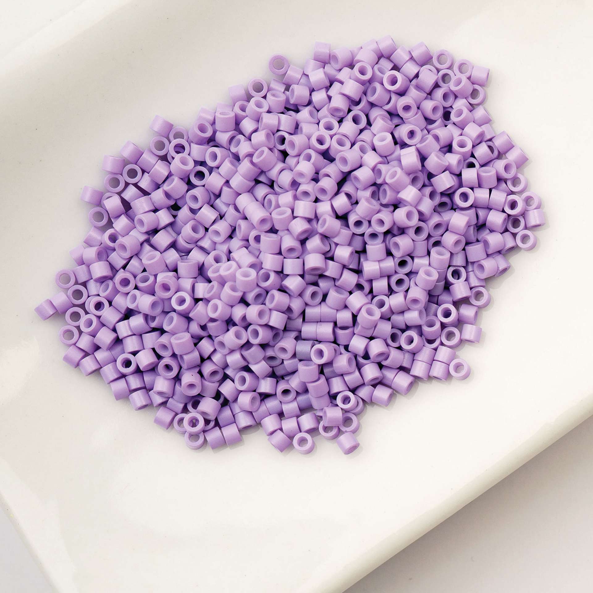 John Bead Cylin 11/0 Cylindrical Seed Beads - Light Purple Opaque sitting in dish