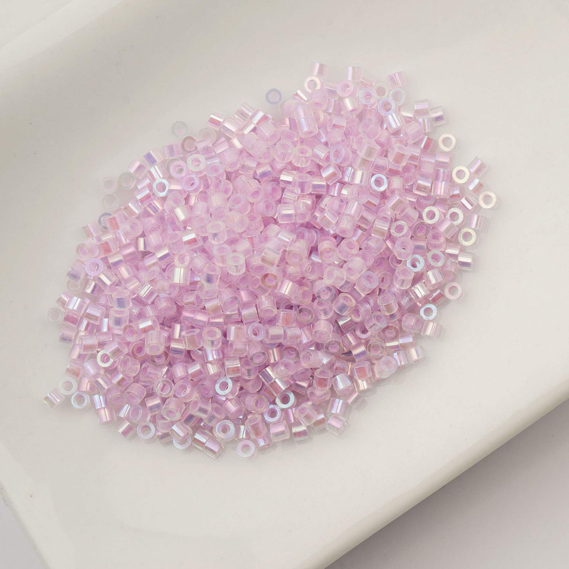 John Bead Cylin 11/0 Glow in the Dark Cylindrical Seed Beads - Violet AB, 25g sitting in dish