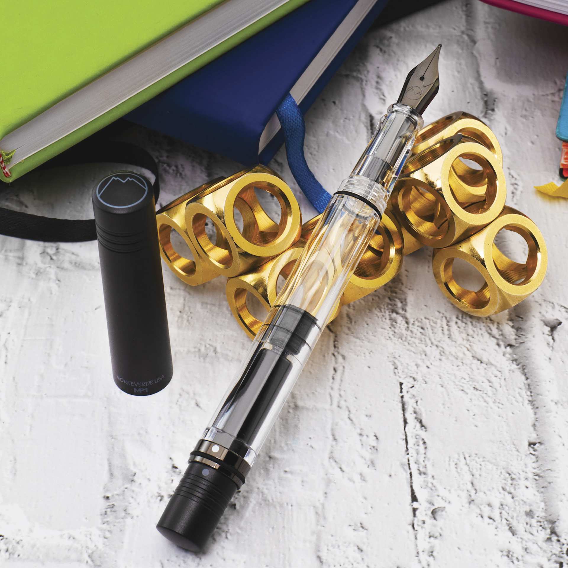 Monteverde MP1 Omniflex Fountain Pen - Black Noir, propped up next to notebooks (image may reflect a different nib)