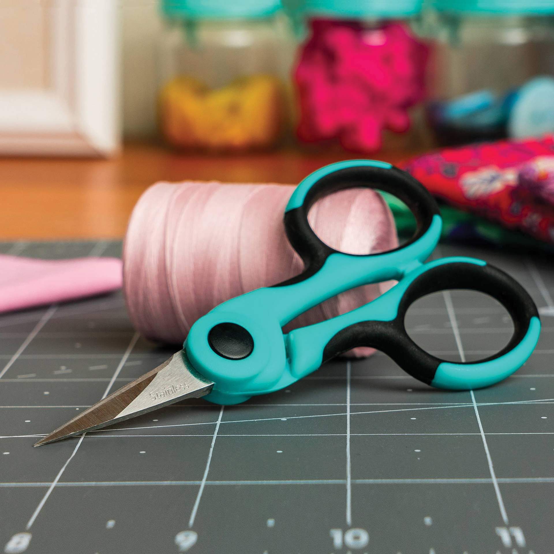 Singer ProSeries Detail Scissors, leaning against embroidery floss roll