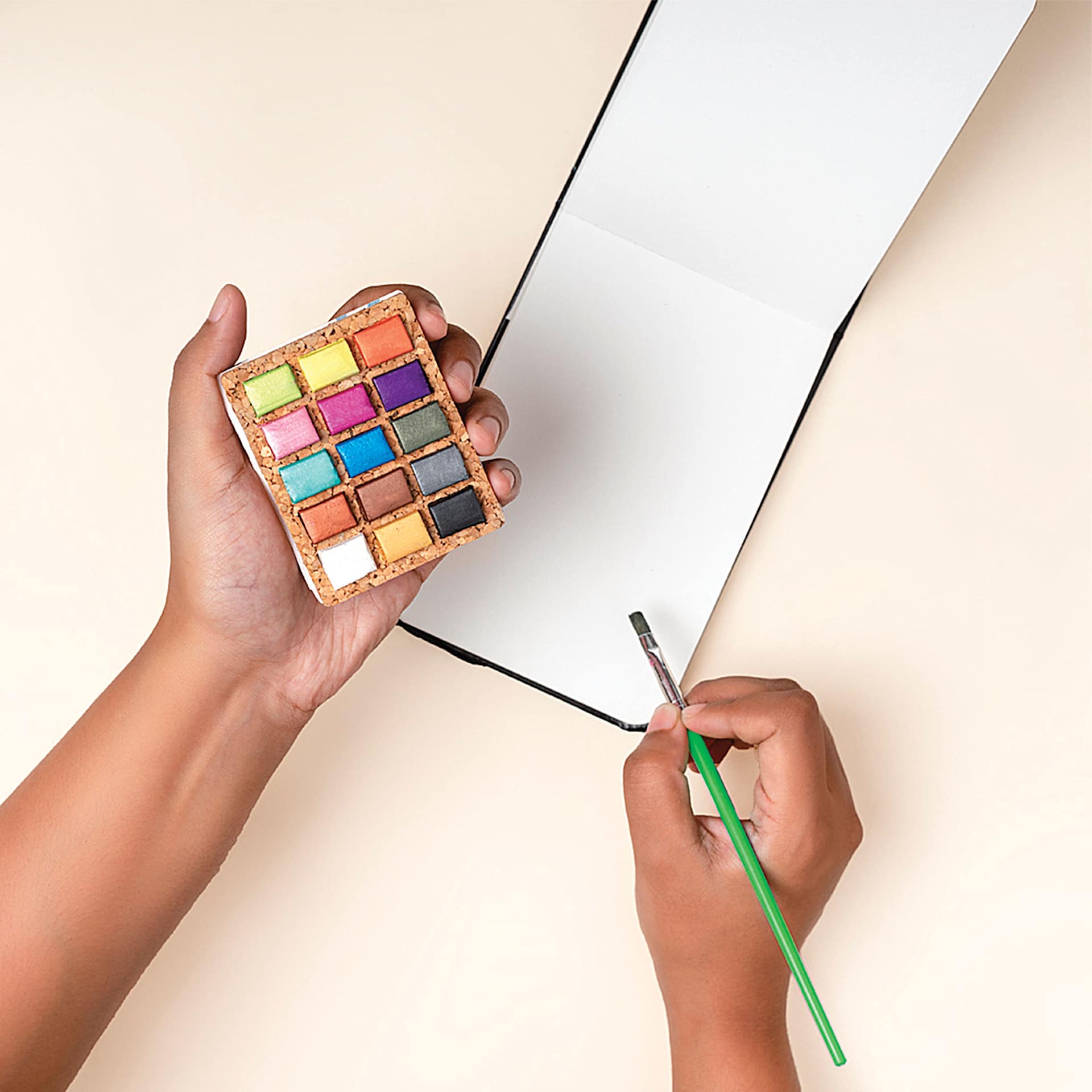 Person holding the Viviva Watercolor Paint Pan Set in Metallic. Person holding the Viviva Watercolor Paint Pan Set in Metallic.