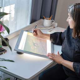 Person using the 12" x 17" Artograph LED LightPad.