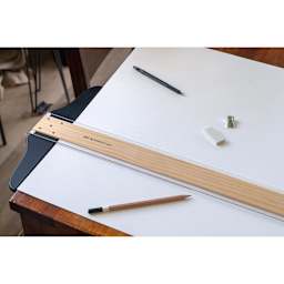 Art Alternatives Wooden Acrylic Edged T-Square - 36" being used on the edge of a table
