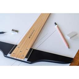 Art Alternatives Wooden Acrylic Edged T-Square - 36" sitting on a table with other drawing material